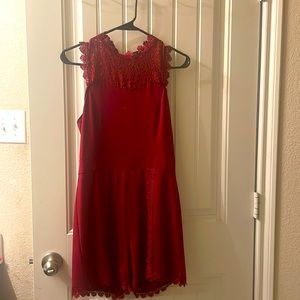 Burgundy romper with detailed fringe outlining.